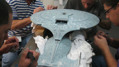 Thumbnail of The Cinema Arts team gathers around the Enterprise D to work on its finer details.